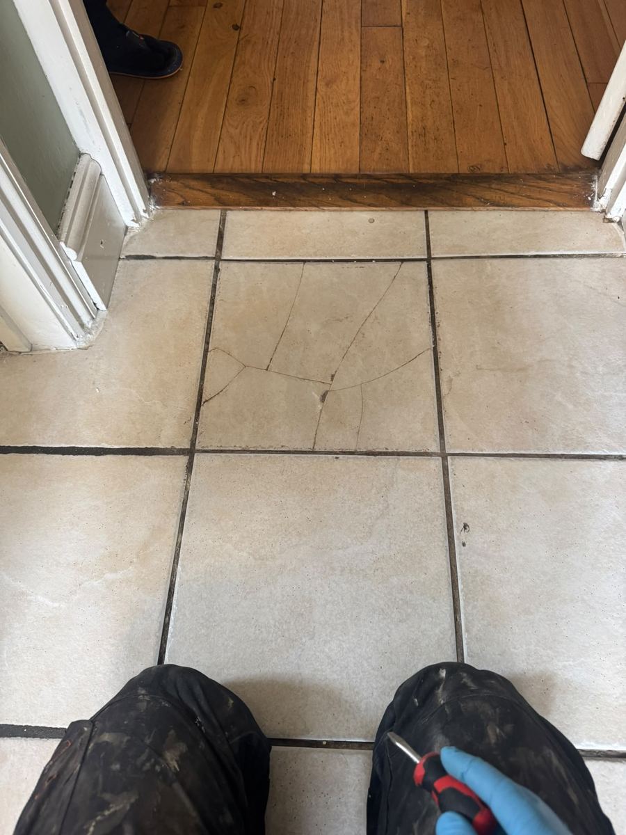 Floor tile put back together at a kitchen doorway after the leak repair